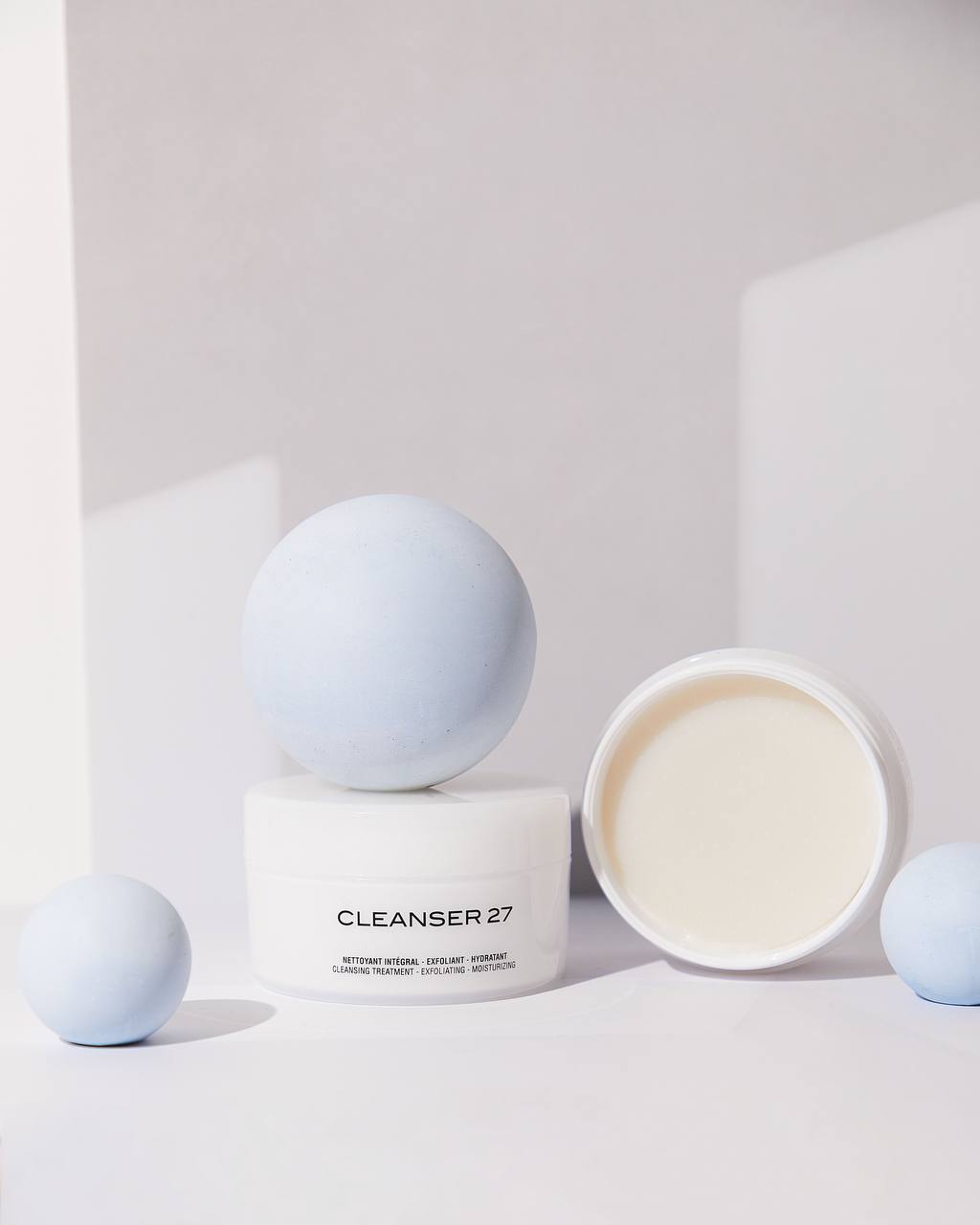 Cosmetic jar presented with simple pastel display forms and generous negative space