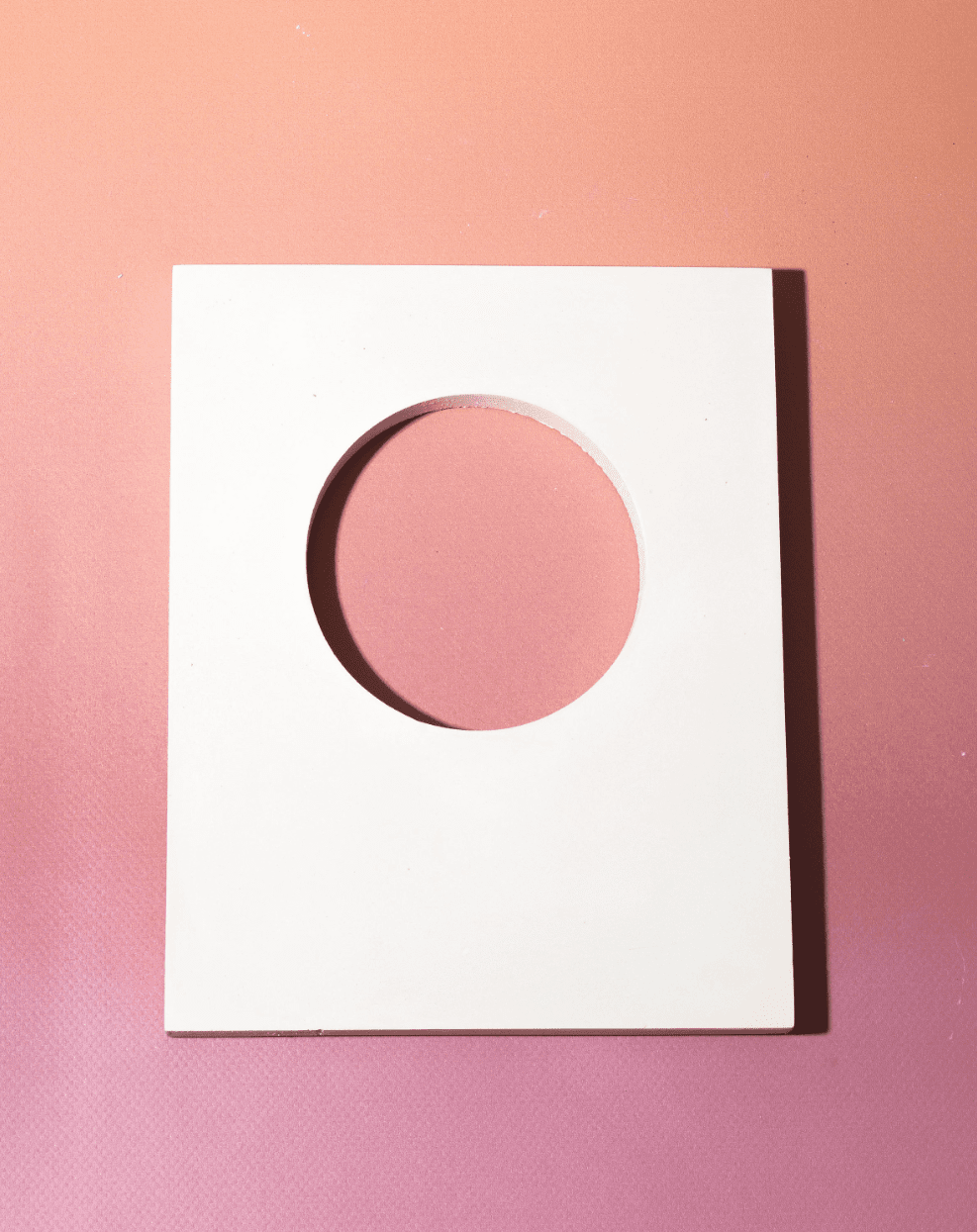 White rectangular cut-out styling panel with circular opening for beauty product photography and campaign styling
