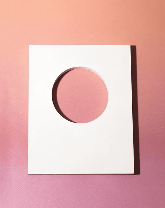White rectangular cut-out styling panel with circular opening for beauty product photography and campaign styling