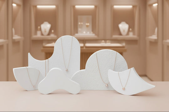 Sculptural display stand set "Dune" styled in a luxury jewelry boutique with backlit niches, showing scale of organic gypsum risers for retail merchandising