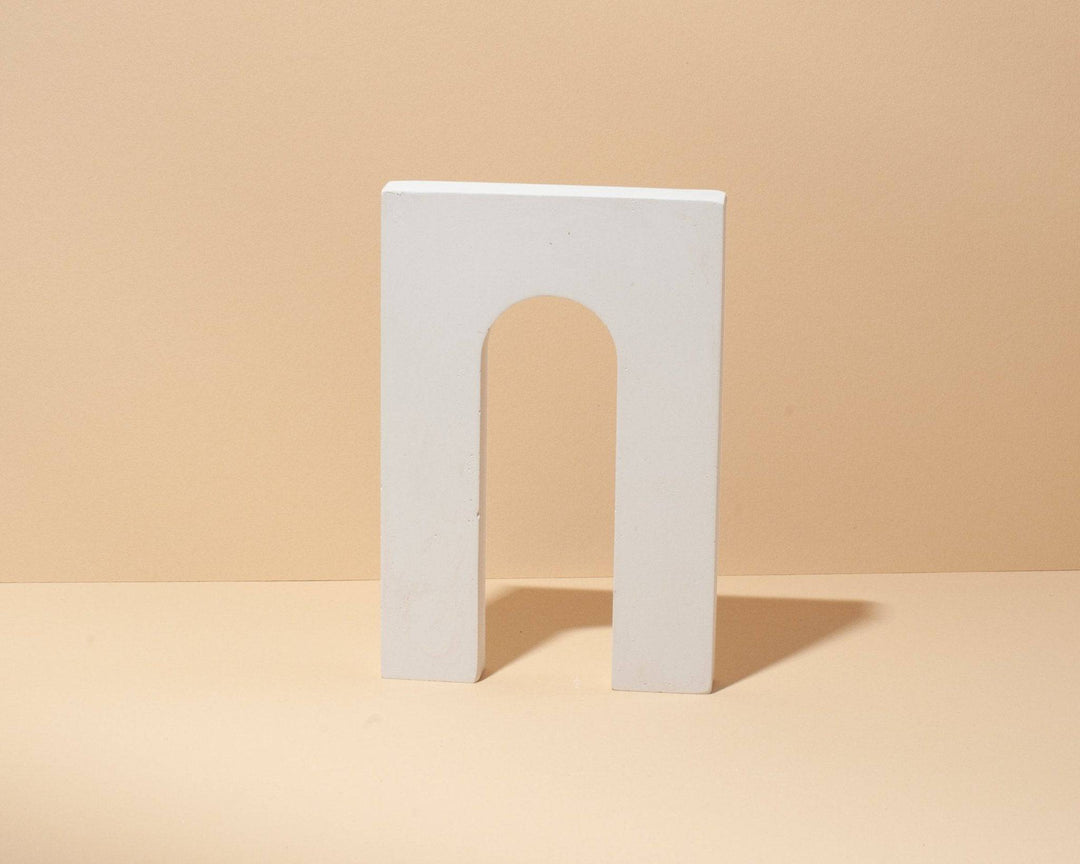 Minimal arch styling form in matte mineral plaster for jewelry photography and editorial styling