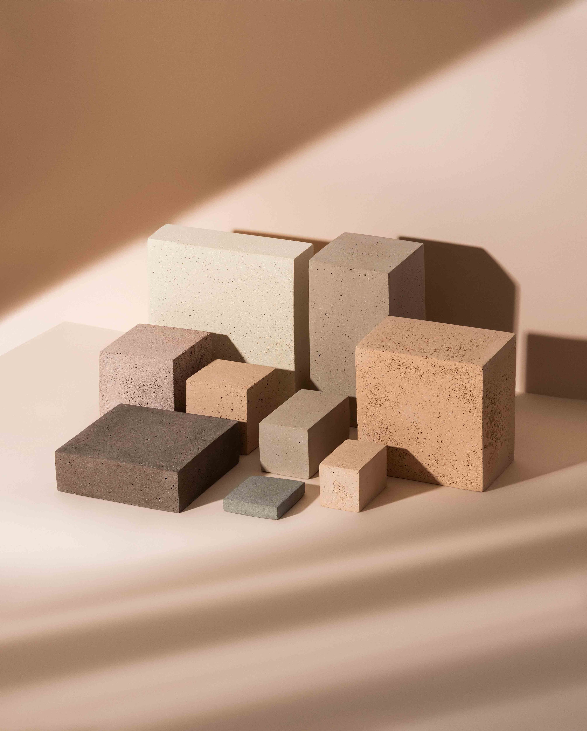 Modular mineral blocks and cubes in warm directional light, showing how an art director builds depth through height, scale and shadow