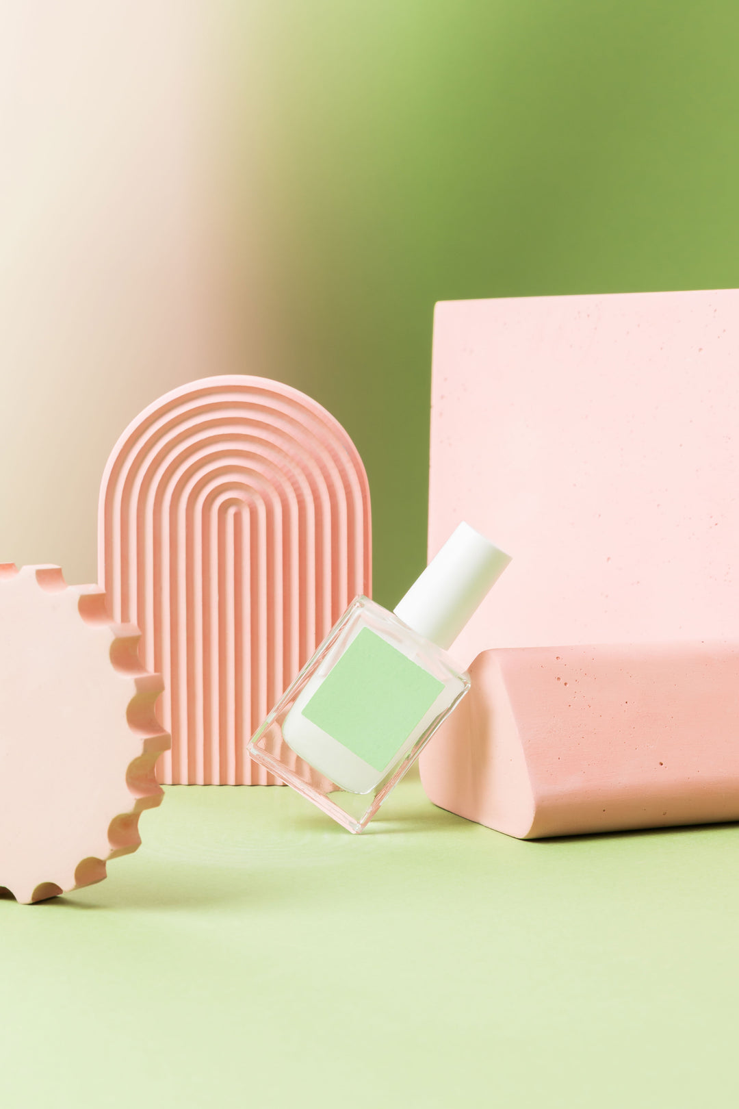A campaign variation using coral and green geometry, layered heights and a blank beauty bottle