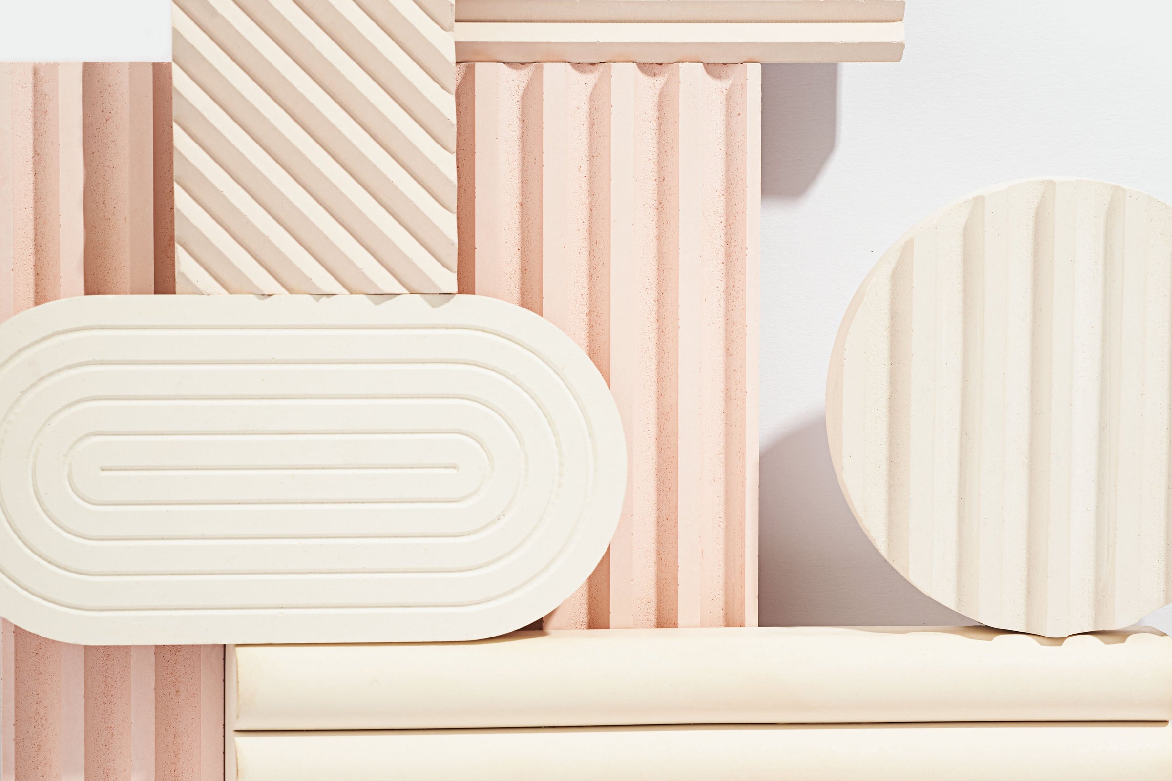 Collection of geometrically shaped objects in pastel colors on a light background