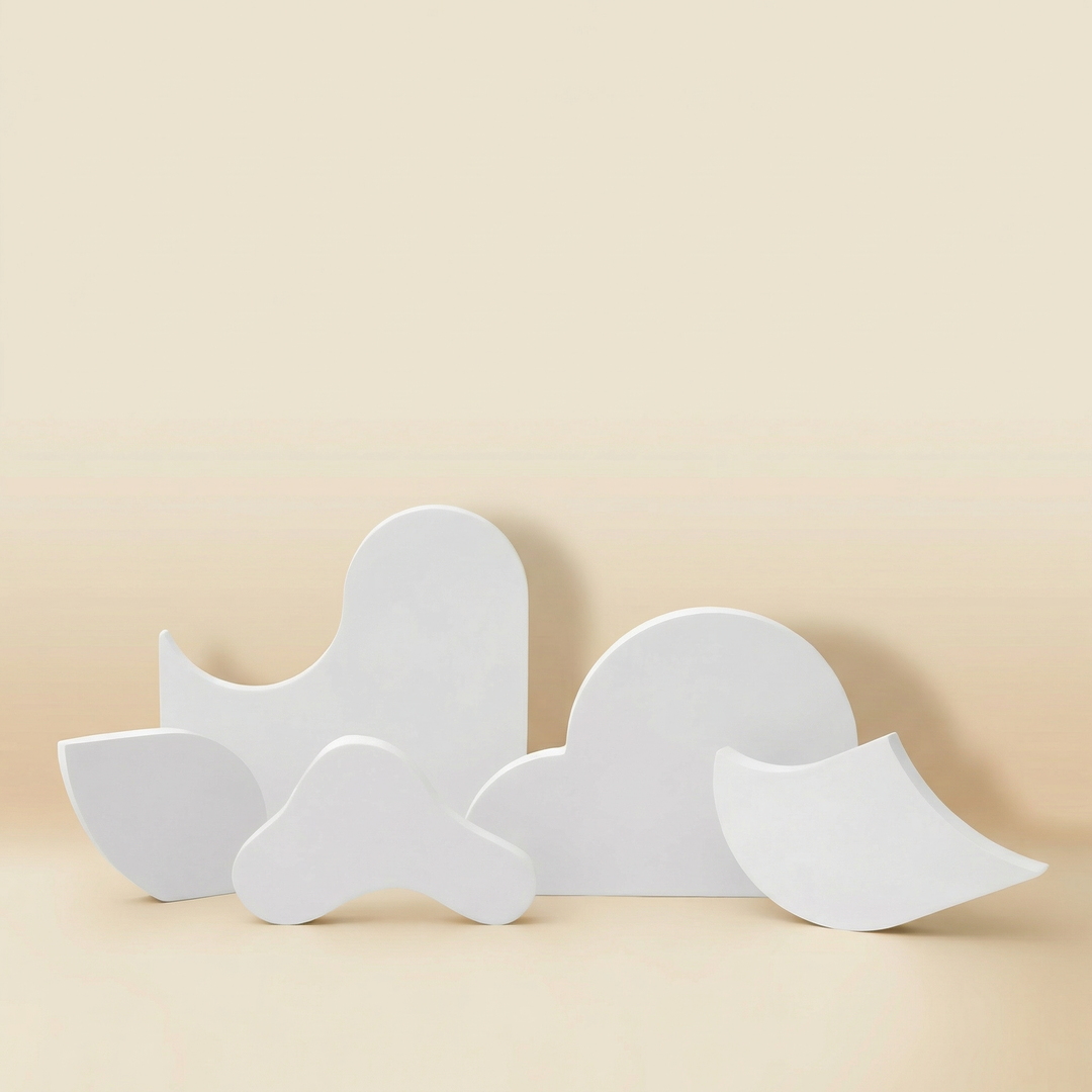 Set of four white sculptural jewelry display stands with organic wave shapes, handmade gypsum risers for necklaces and cosmetics product photography
