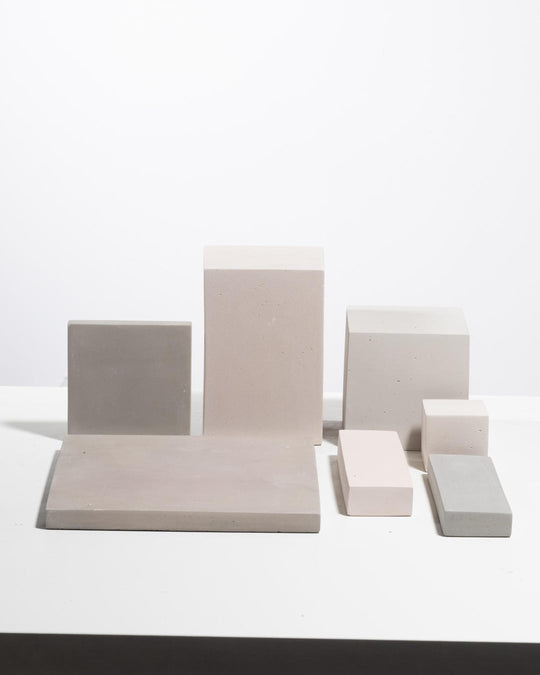 Set of seven geometric concrete display blocks in taupe and stone grey