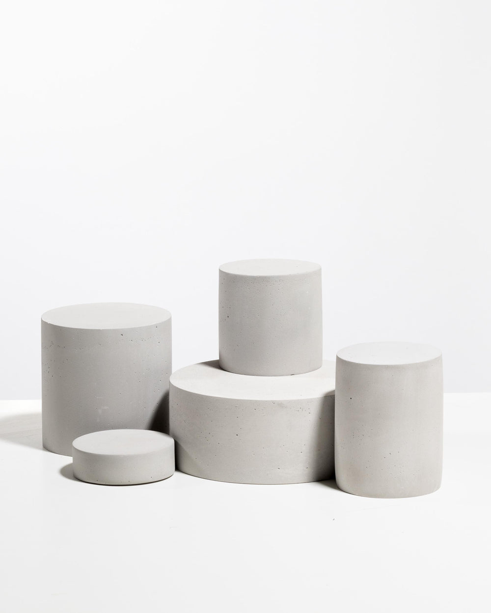 Minimal architectural display riser set in white concrete for cosmetic brands