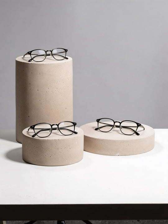 Round display risers in warm gray for eyewear and jewelry presentation