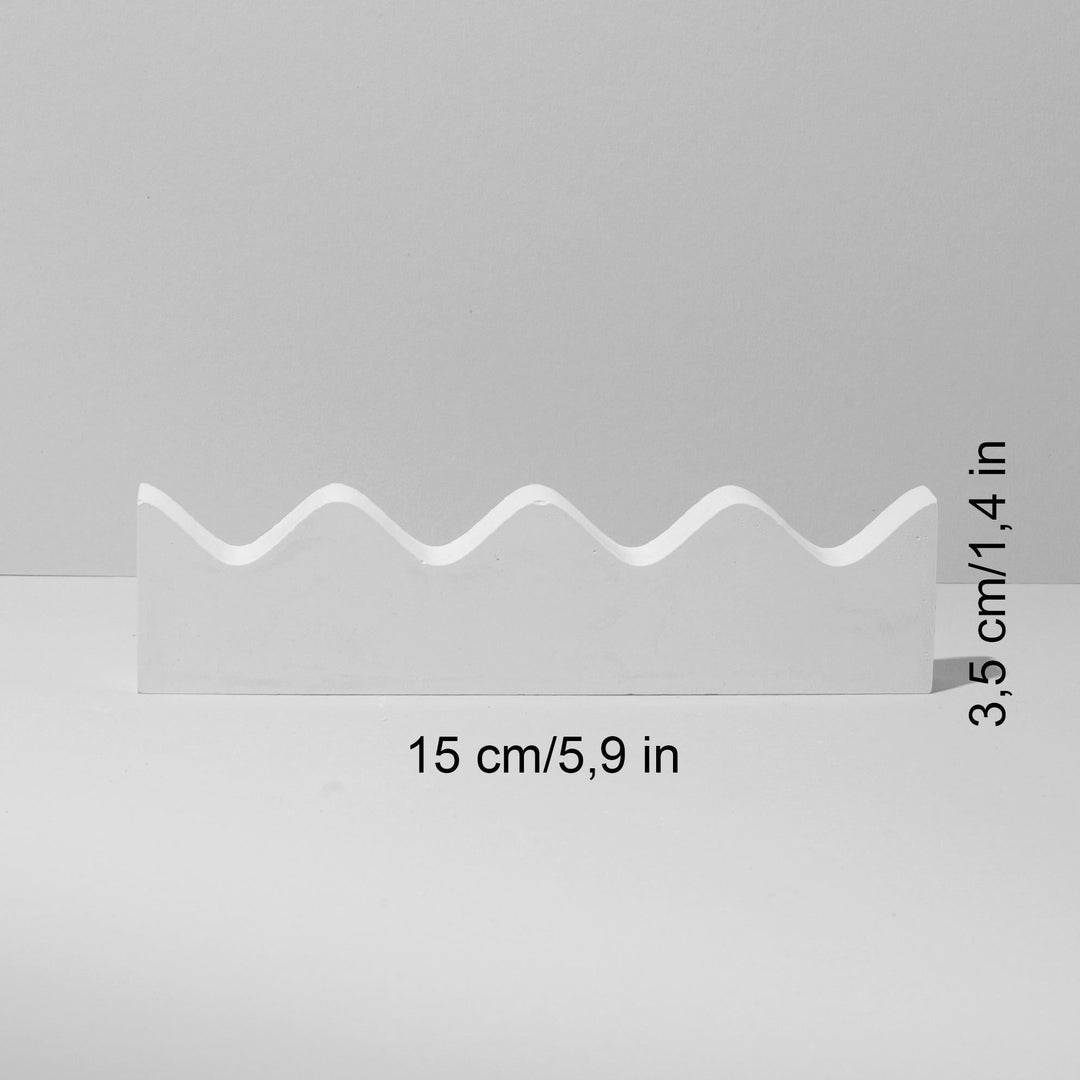 White wave-shaped ring holder with flat base and three rounded peaks