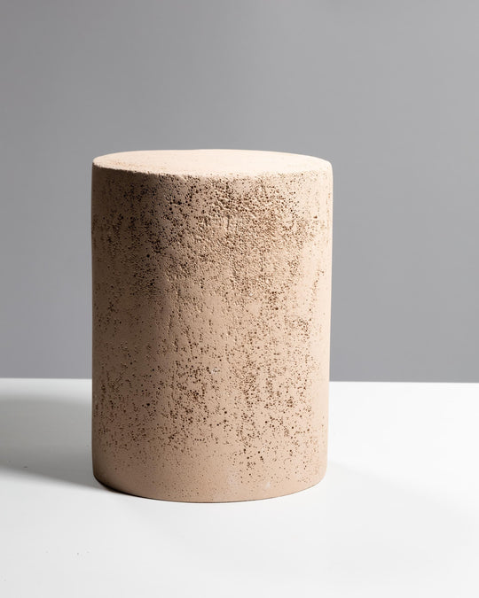 Large sand beige cylinder display podium with porous mineral texture