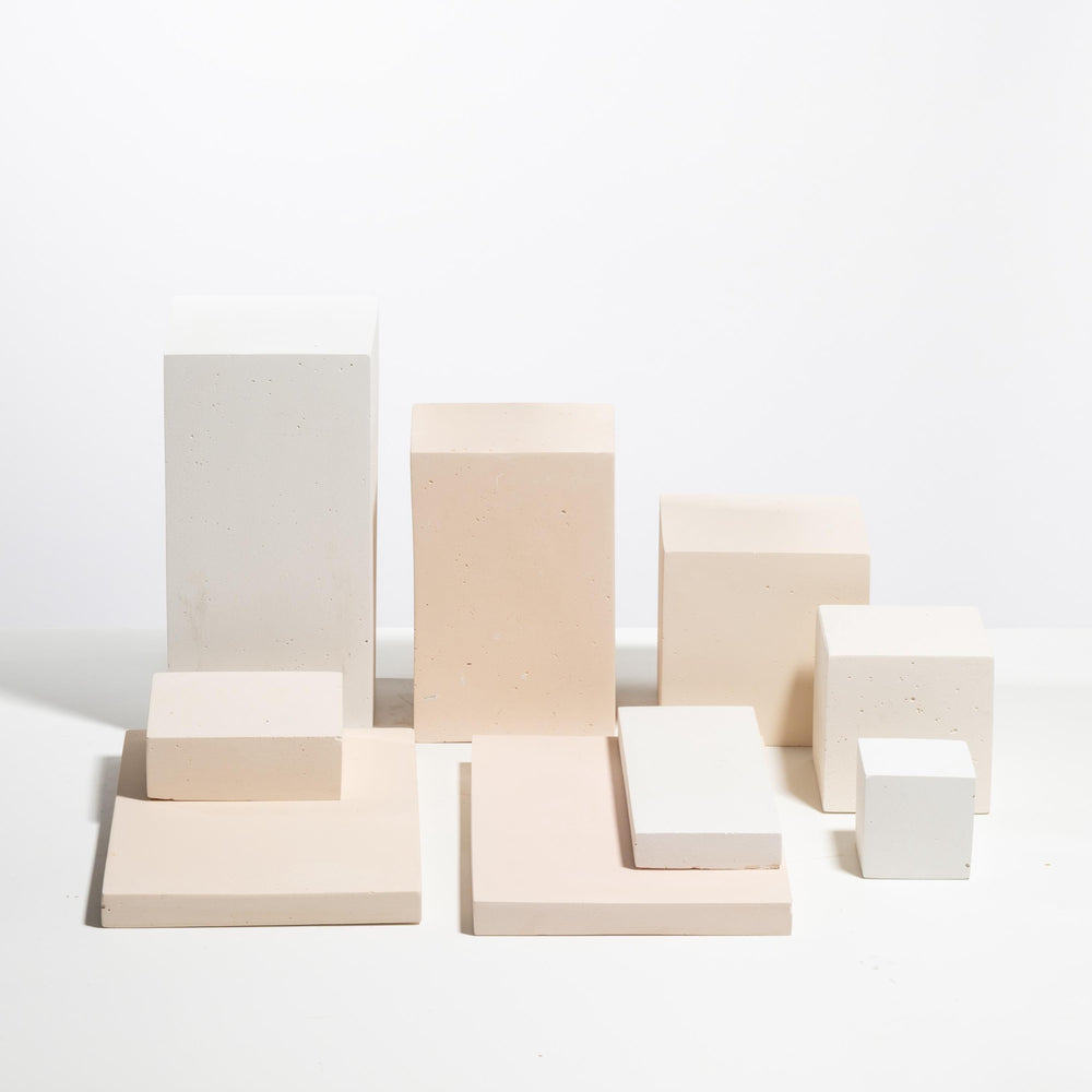 Set of nine white and pale peach display blocks in tiered formation