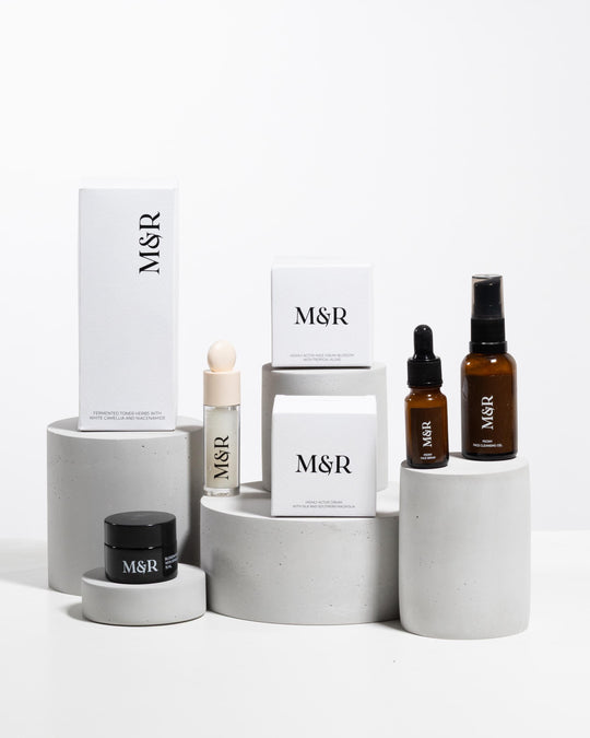 Concrete cylinder display risers styled with luxury skincare packaging on boutique counter