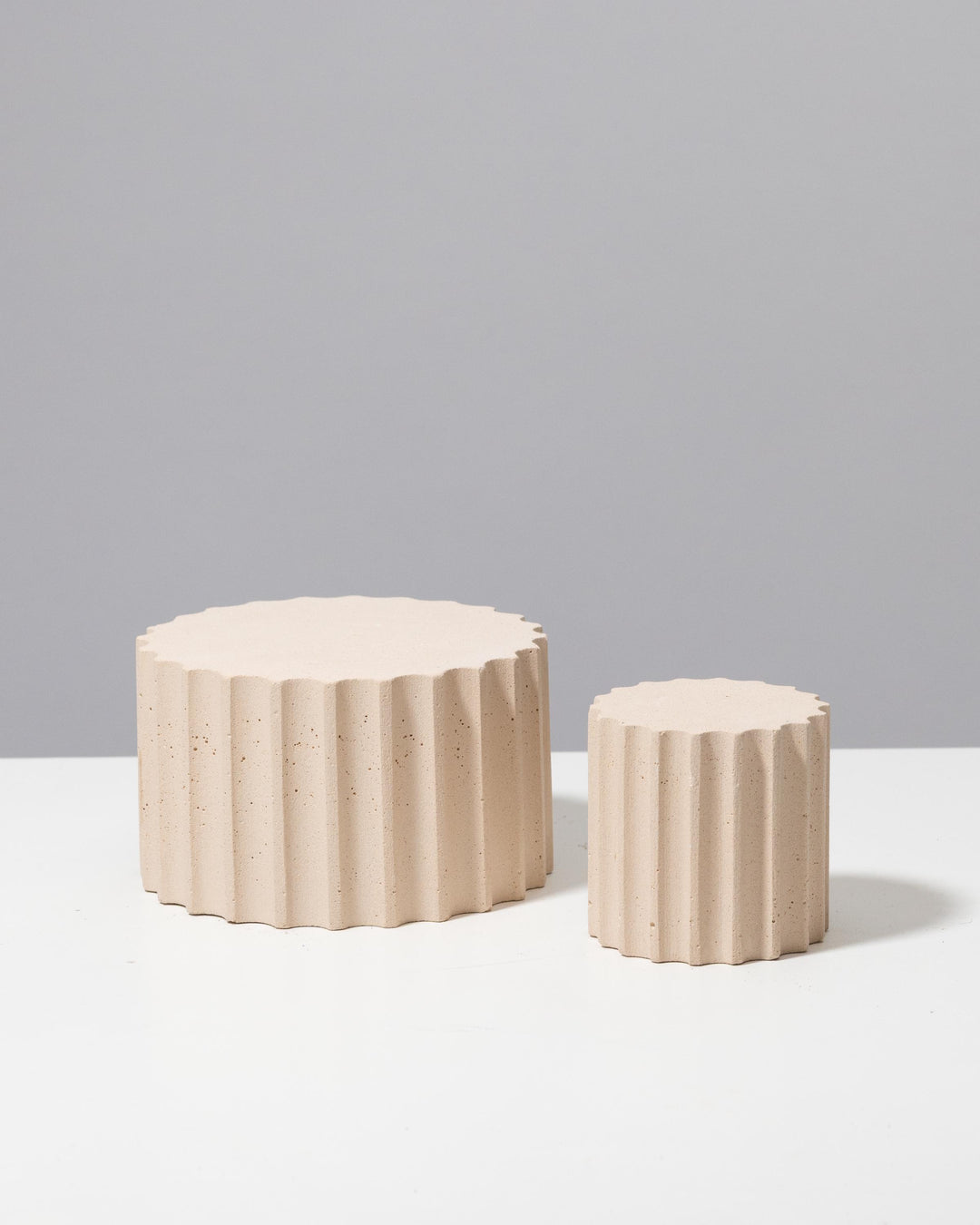 Speckled beige fluted display pedestals with flat tops for jewelry presentation