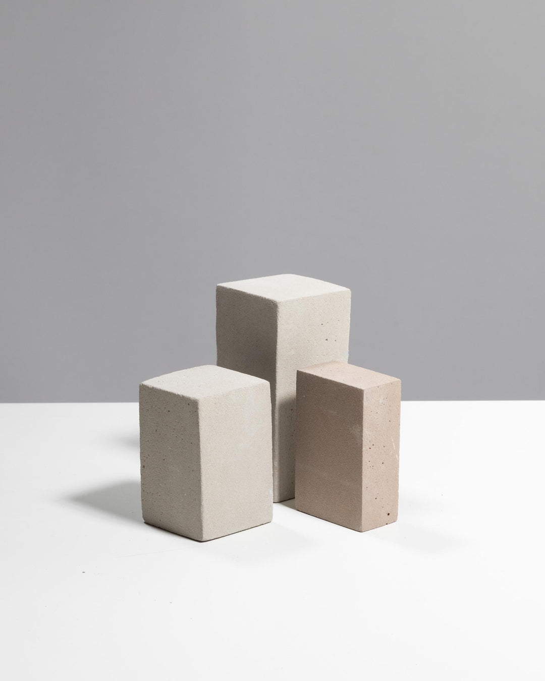 Cluster of grey beige plaster display blocks with matte mineral surface