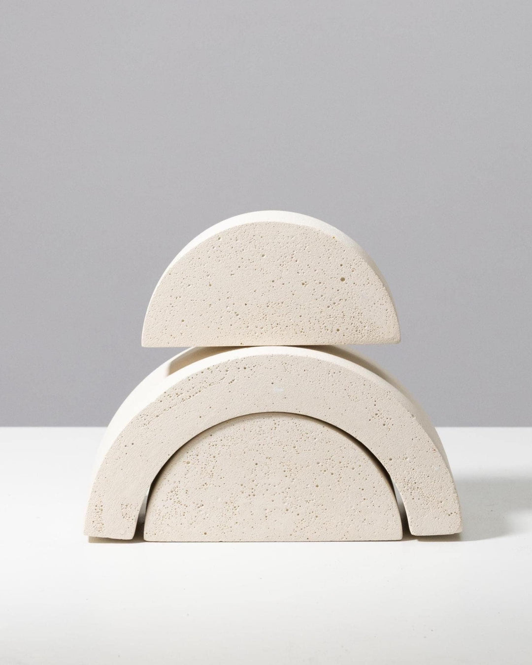 Stacked arrangement of off white arch and half circle display risers