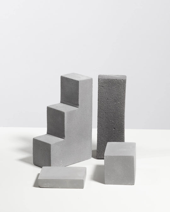 Grey plaster display set with three step riser, tall column block, low platform and small block