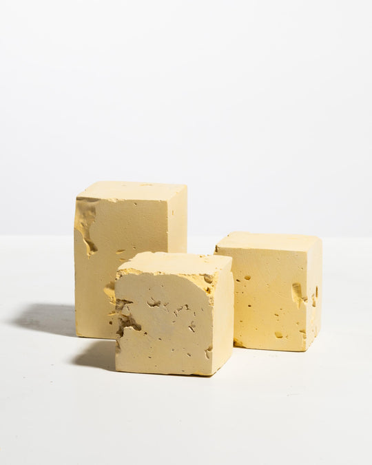 Three pale yellow textured display blocks, tall block and two cubes