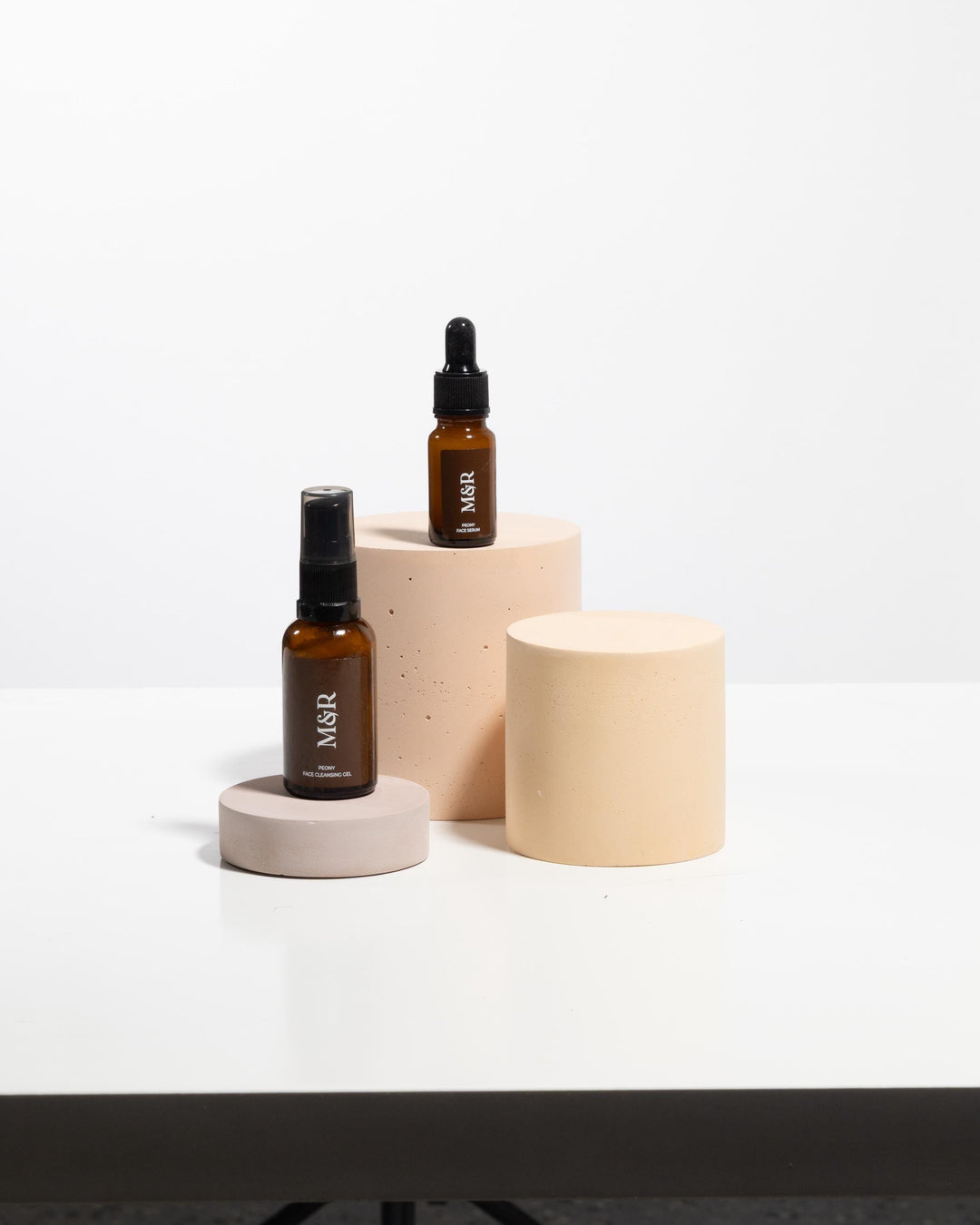 Exhibition product plinths in varying heights styled with amber glass bottles