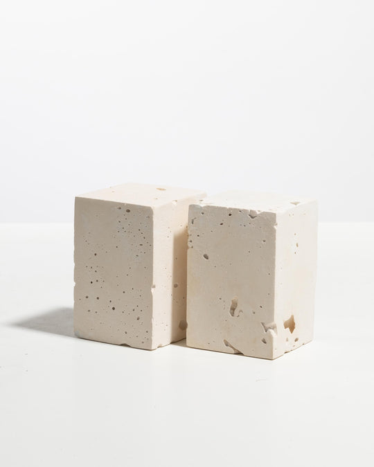 Two ivory plaster rectangular display blocks with porous mineral texture
