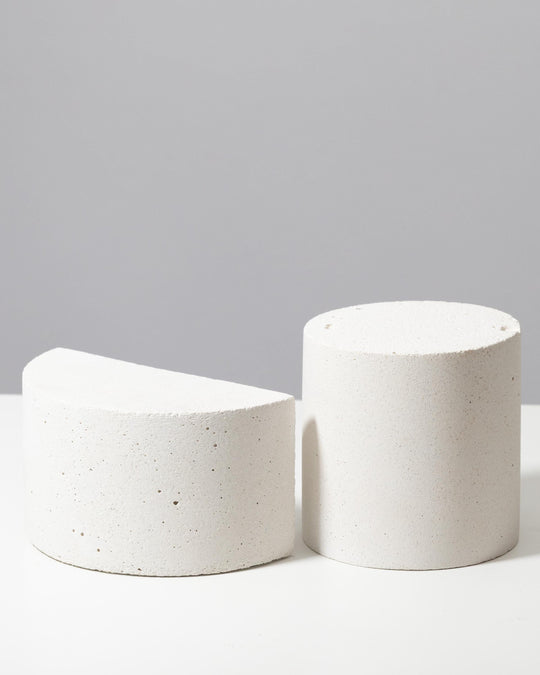 Textured white cylinder and half cylinder display pedestals with porous mineral surface