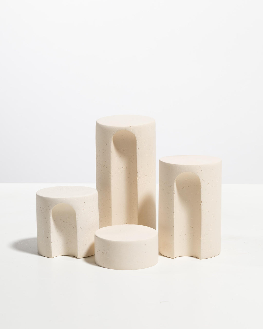 Arched cylinder jewelry display podiums with speckled plaster finish