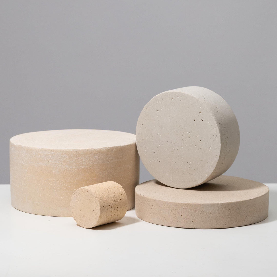 Round pedestal and disc set clustered together in beige and light grey