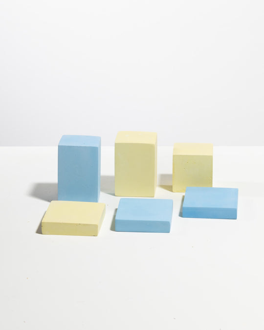 Concrete retail display cube set of six in pastel blue and pale yellow with tall blocks and flat square bases